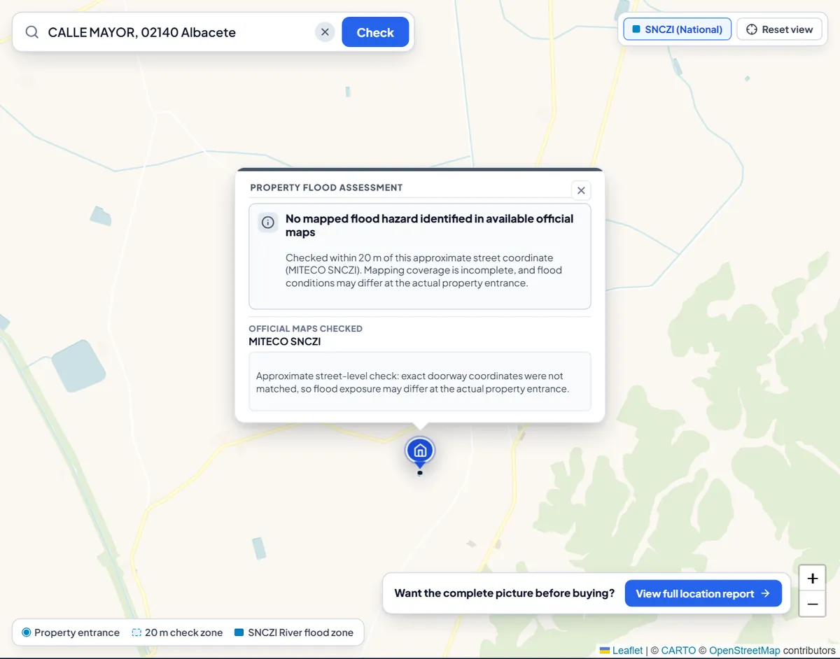 Flood check for a street in Albacete: the result card says no mapped flood hazard was identified in available official maps and that mapping coverage is incomplete