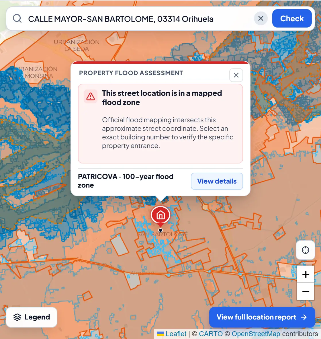 BarrioRadar flood check for a street in Orihuela, Alicante: the property marker sits inside shaded official flood zones and the result card reads This street location is in a mapped flood zone, PATRICOVA 100-year flood zone